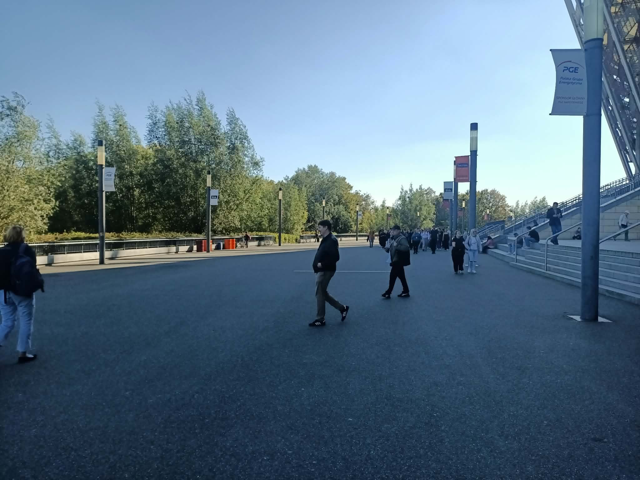 Grupy uczestników na terenie przed stadionem PGE Narodowy.